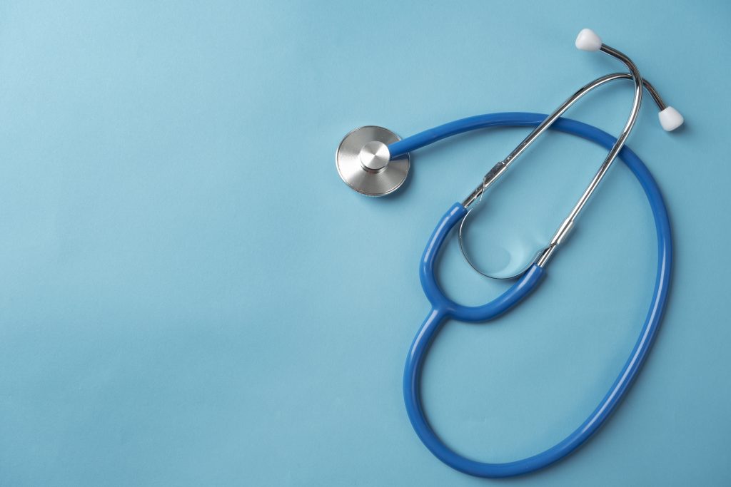 Estetoscópio azul utilizado na medicina, representando a prática médica e o cuidado com a saúde.